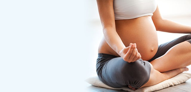 Pregnant woman meditating and practicing yoga
