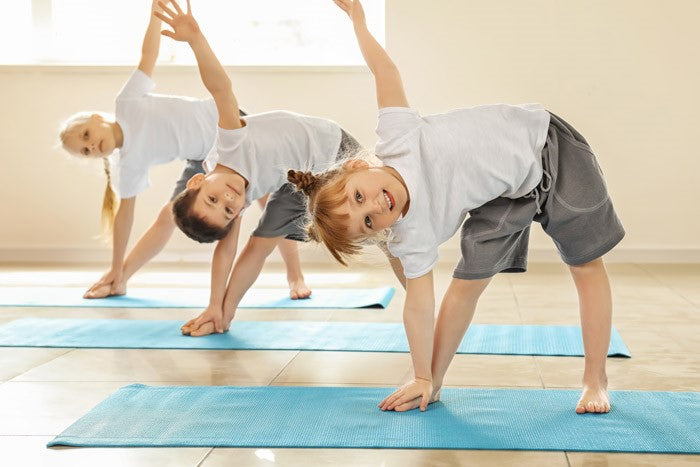 3 children practicing yoga indoors