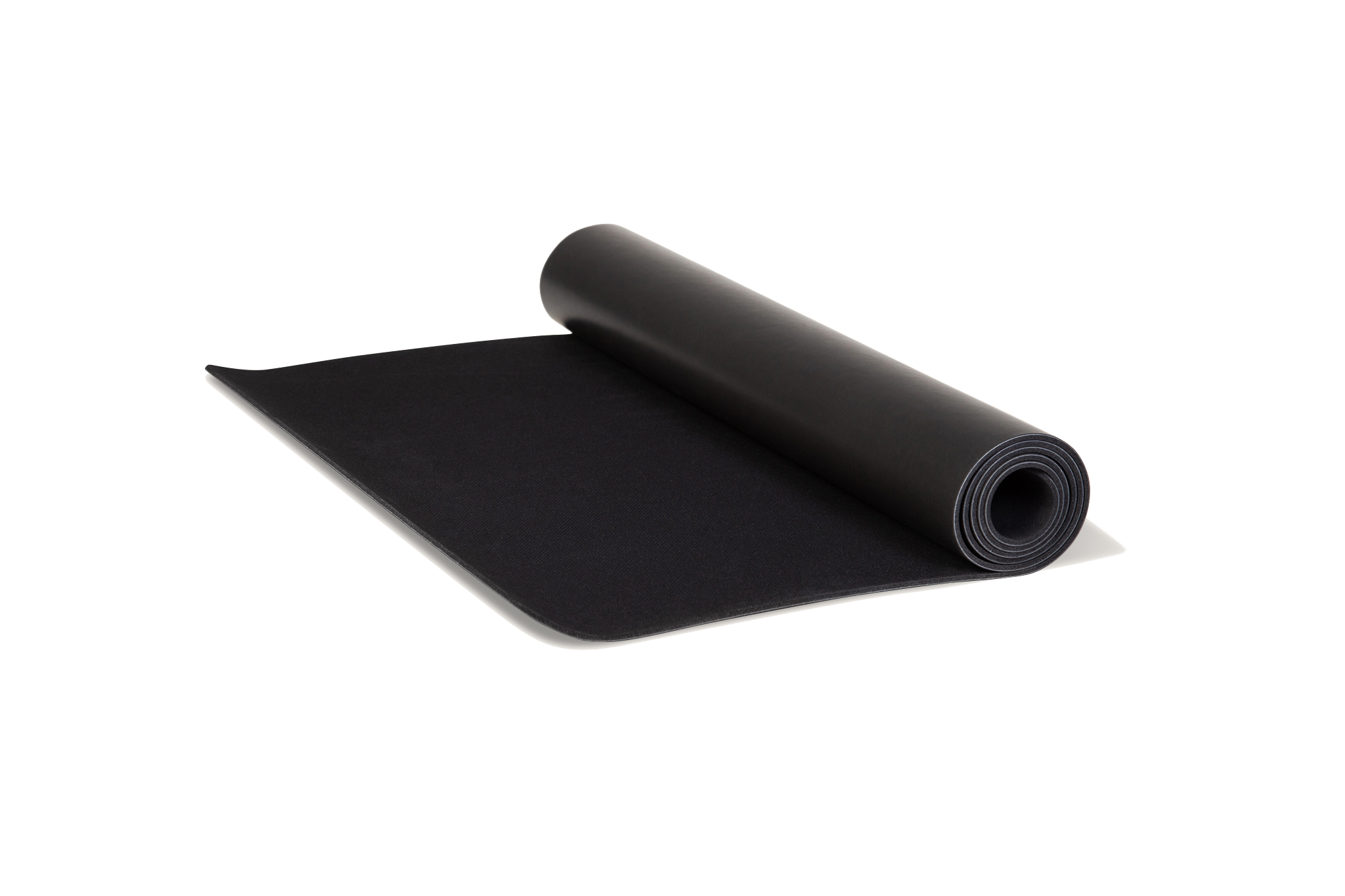 Eco-friendly black yoga mat unrolling made from natural tree rubber.
